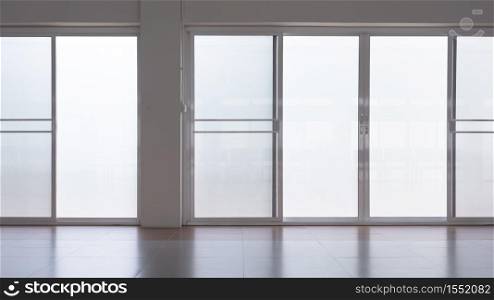 Front view of frosted glass sliding doors with screen doors and light reflection on tile floor surface in empty room