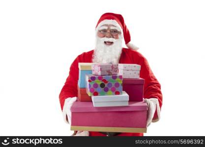 Front view of happy Santa Claus carrying Christmas gifts over white background