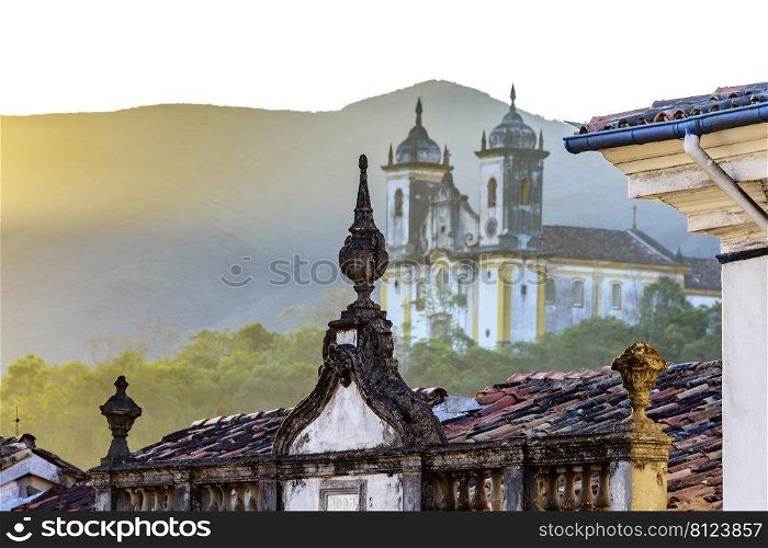 Front view of historic colonial style houses and church in the background in Ouro Preto city, Minas Gerais state, Brazil. Front view of historic colonial style houses and church in the background