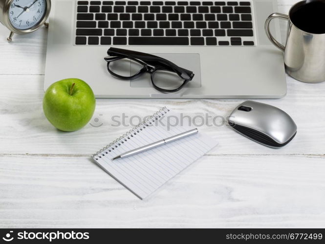 Front view of laptop computer with office work objects and coffee. Layout in horizontal format.