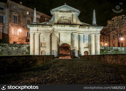 Front view of Porta San Giacomo and the walls of the upper city of Bergamo. Fortified and historical urban complex in Italy. Night cityscape.