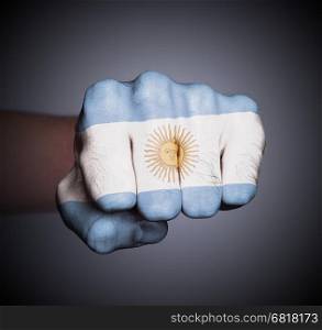 Front view of punching fist on gray background, flag of Argentina