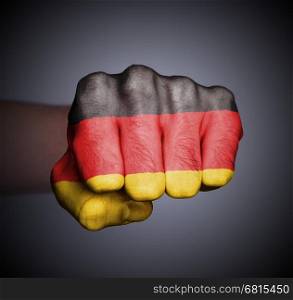 Front view of punching fist on gray background, flag of Germany