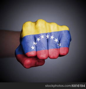 Front view of punching fist on gray background, flag of Venezuela