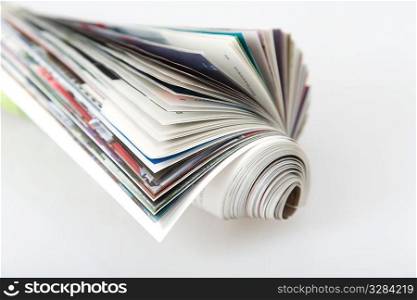 front view of roll magazine, colored newspaper on white background