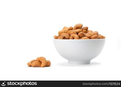 front view of salted cashew nuts in white ceramic bowl isolated on white background with soft shadow