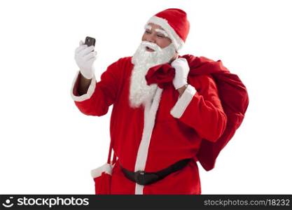 Front view of Santa Claus looking at mobile phone while carrying sack of Christmas presents