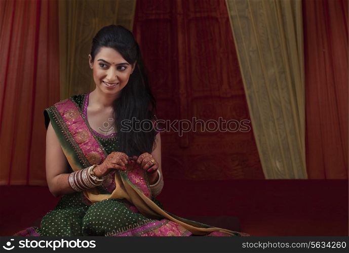 Front view of smiling young bride sitting