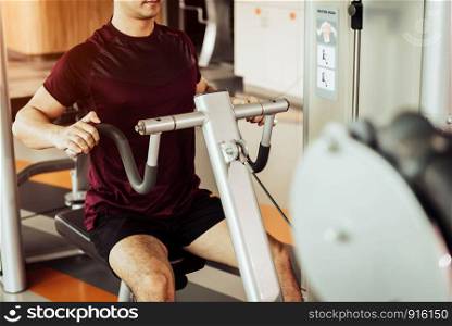 Front view of sport man using back muscle stretch machine called seated row in fitness gym. People lifestyles and Sport workouts concept. Close up view