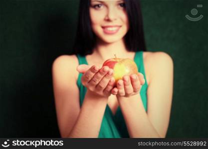 Front view of the 20s female holding an apple in her hands, focus on the apple