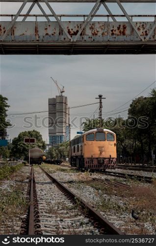 Front view of The diesel electric locomotive is parked on Old railroad tracks. The empty passenger yellow train, Selective focus.
