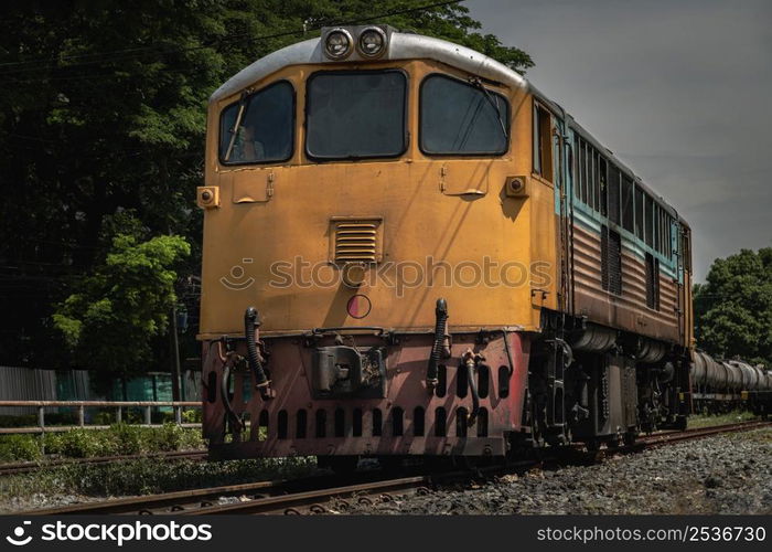 Front view of The diesel electric locomotive is parked on Old railroad tracks. The empty passenger yellow train, Selective focus.