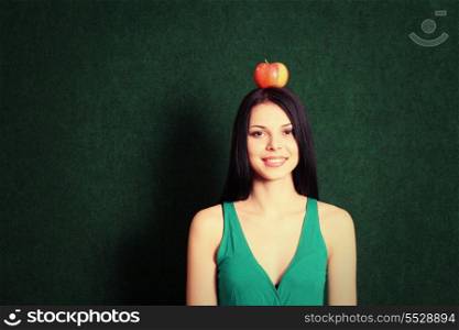 front view of the young female with an apple on her head and a lot of copyspace