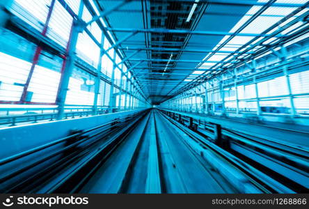 Front view of train moving in city rail tunnel with moderate motion blur and blue tone filter. Transportation concept and motion blur background abstract.