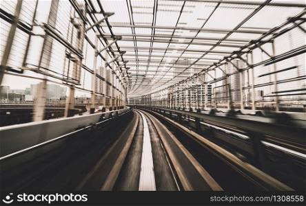 Front view of train moving in city rail tunnel with moderate motion blur and sepia color filter. Transportation concept and motion blur background abstract.