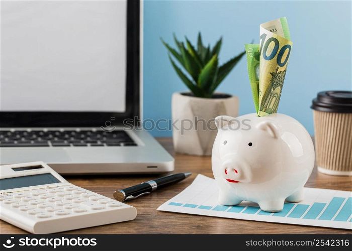 front view office items with growth chart piggy bank