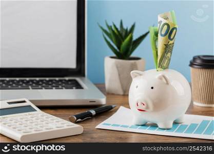 front view office items with growth chart piggy bank