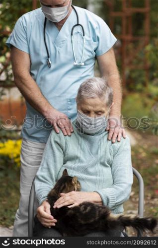 front view older woman with medical mask cat taken care by male nurse