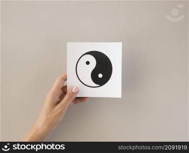 front view person holding ying yang symbol