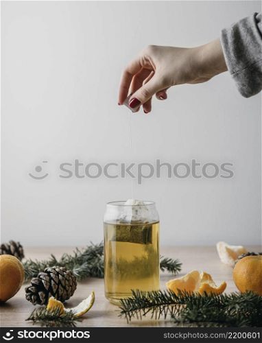 front view person taking tea bag out jar