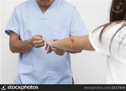 front view physiotherapist doing fingers exercises with woman