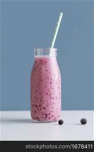 front view pink smoothie bottle with straw blueberries