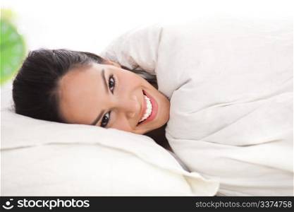 Front view portrait of beautiful resting woman cover in white sheet