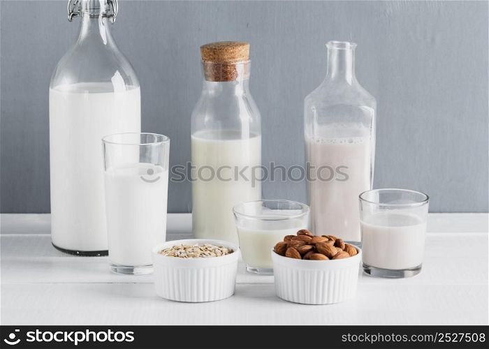 front view set milk bottles glasses with oatmeal almonds