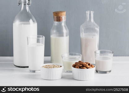 front view set milk bottles glasses with oatmeal almonds