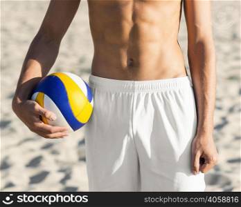 front view shirtless male volleyball player torso holding ball beach