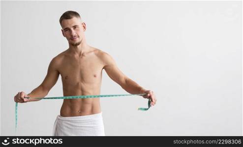 front view shirtless man holding measuring tape with copy space