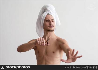 front view shirtless man with towel his head looking his fingernails