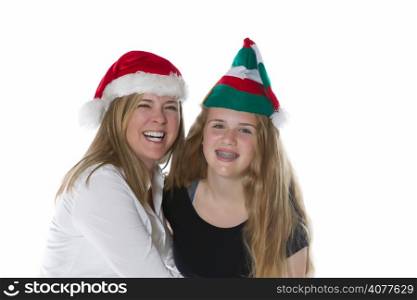 Front view, shoulders up, of mother and her teen daughter wearing Christmas hats isolated on a white background