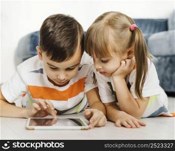 front view siblings using digital tablet