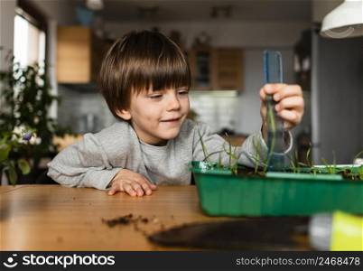 front view smiley boy measuring plant growing home
