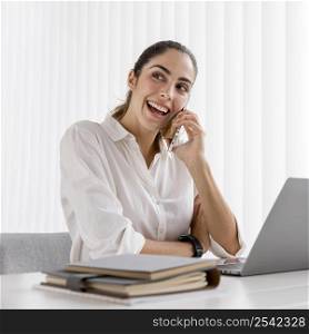 front view smiley businesswoman working with smartphone laptop