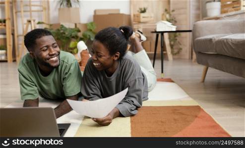 front view smiley couple making plans redecorate house with laptop