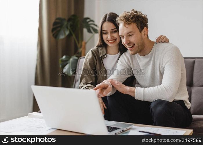 front view smiley couple making plans remodel home together