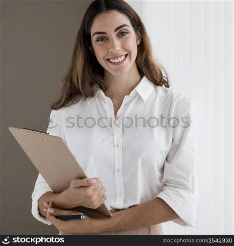front view smiley elegant businesswoman holding clipboard