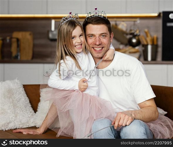 front view smiley father daughter playing with tiara wand together
