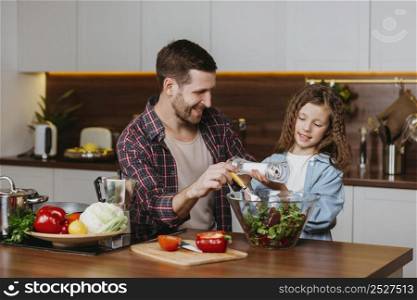 front view smiley father with daughter preparing food kitchen