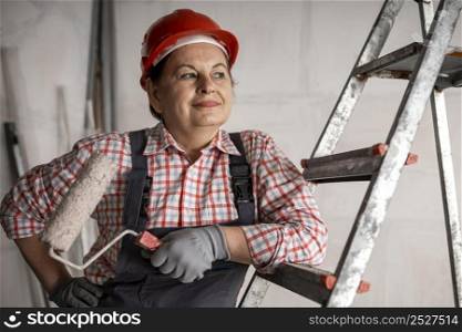 front view smiley female construction worker with paint roller