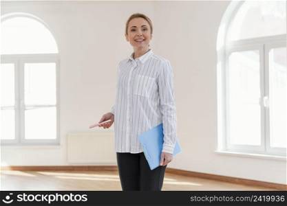 front view smiley female realtor empty house