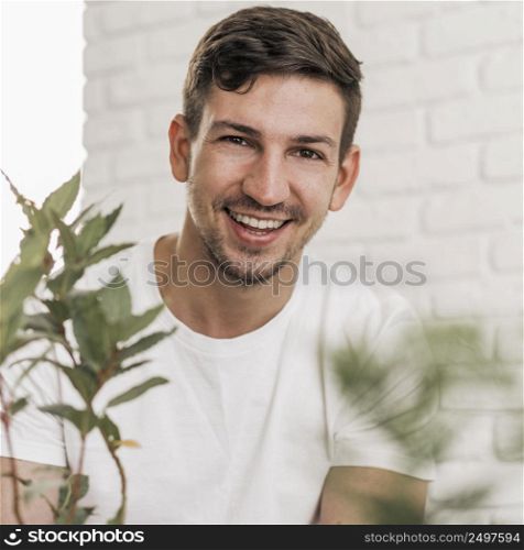 front view smiley man sitting plants