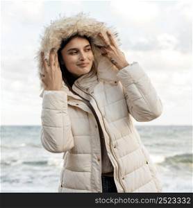 front view smiley woman beach with winter jacket