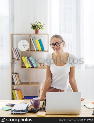 front view smiley woman desk working from home