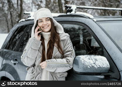 front view smiley woman taking phone while road trip