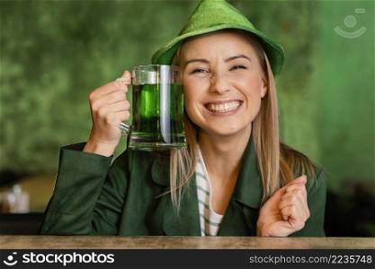 front view smiley woman with hat celebrating st patrick s day with drink