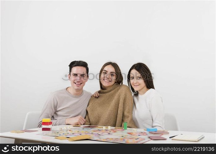 front view smiling friends playing board game