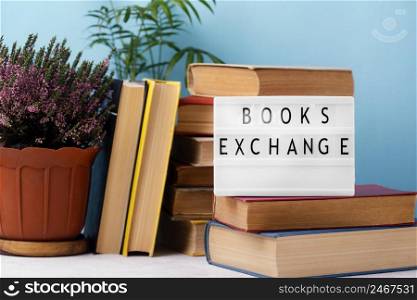 front view stacked books with light box pot plants